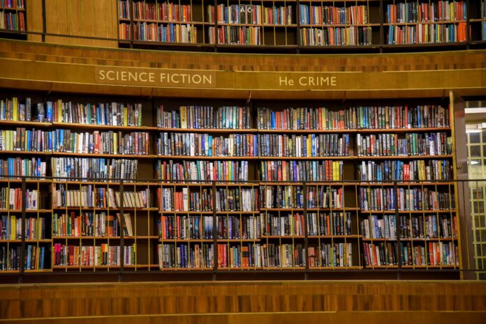 Drewniane regały biblioteczne wypełnione kolorowymi książkami Drewniane regały biblioteczne wypełnione kolorowymi książkami