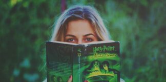 Kobieta czytająca książkę Harry Potter wśród zieleni