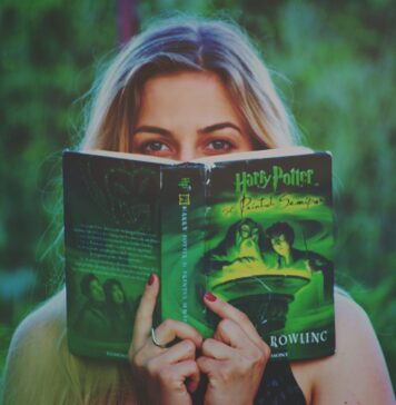 Pięć książek, które koniecznie przeczytaj, zanim obejrzysz ich ekranizacje Kobieta czytająca książkę Harry Potter wśród zieleni