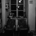 Przytulny kącik w bibliotece z fotelami obok półki z kryminałami
