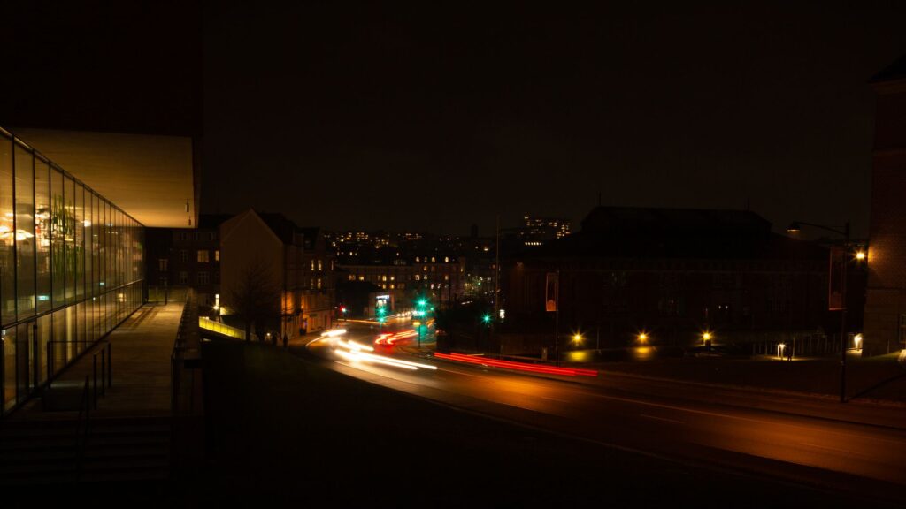Smugi świateł samochodów na nocnej ulicy w Aarhus
